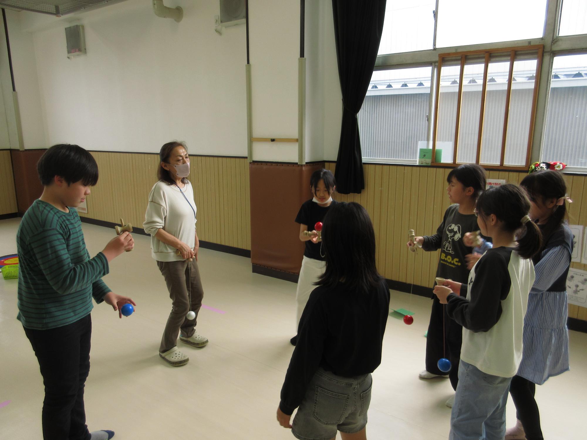 けん玉名人からけん玉を教えてもらっている写真。