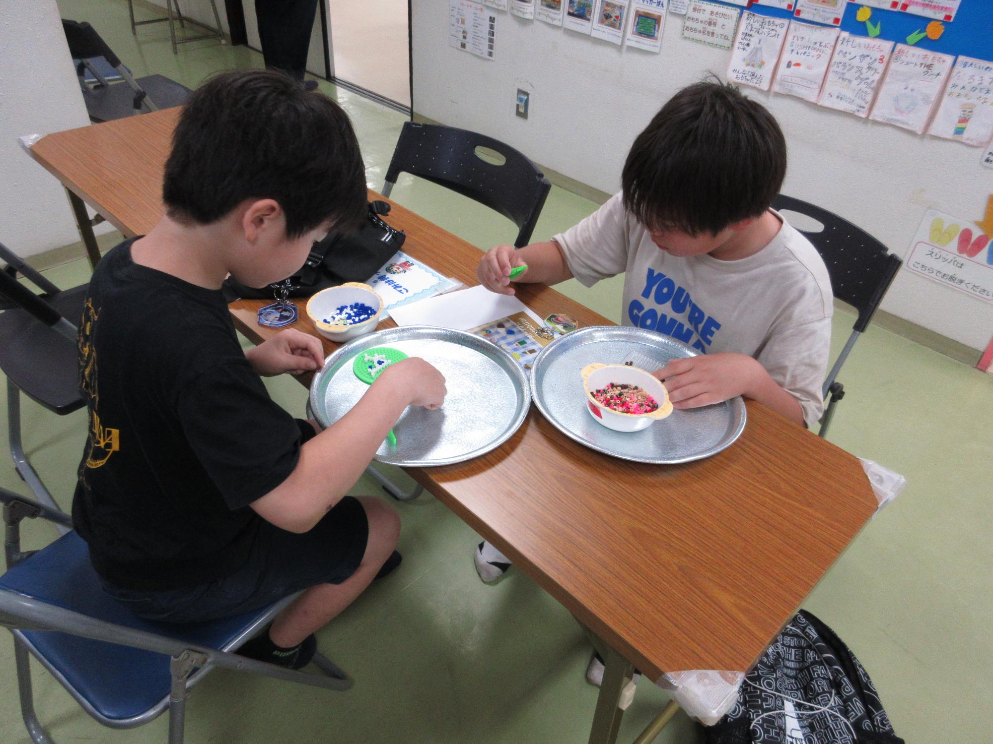 子どもたちがアイロンビーズ作りに取り組んでいる写真