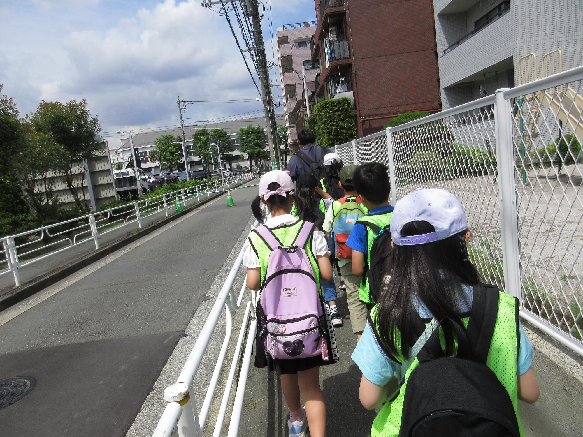 子どもが列になって道を歩いている写真