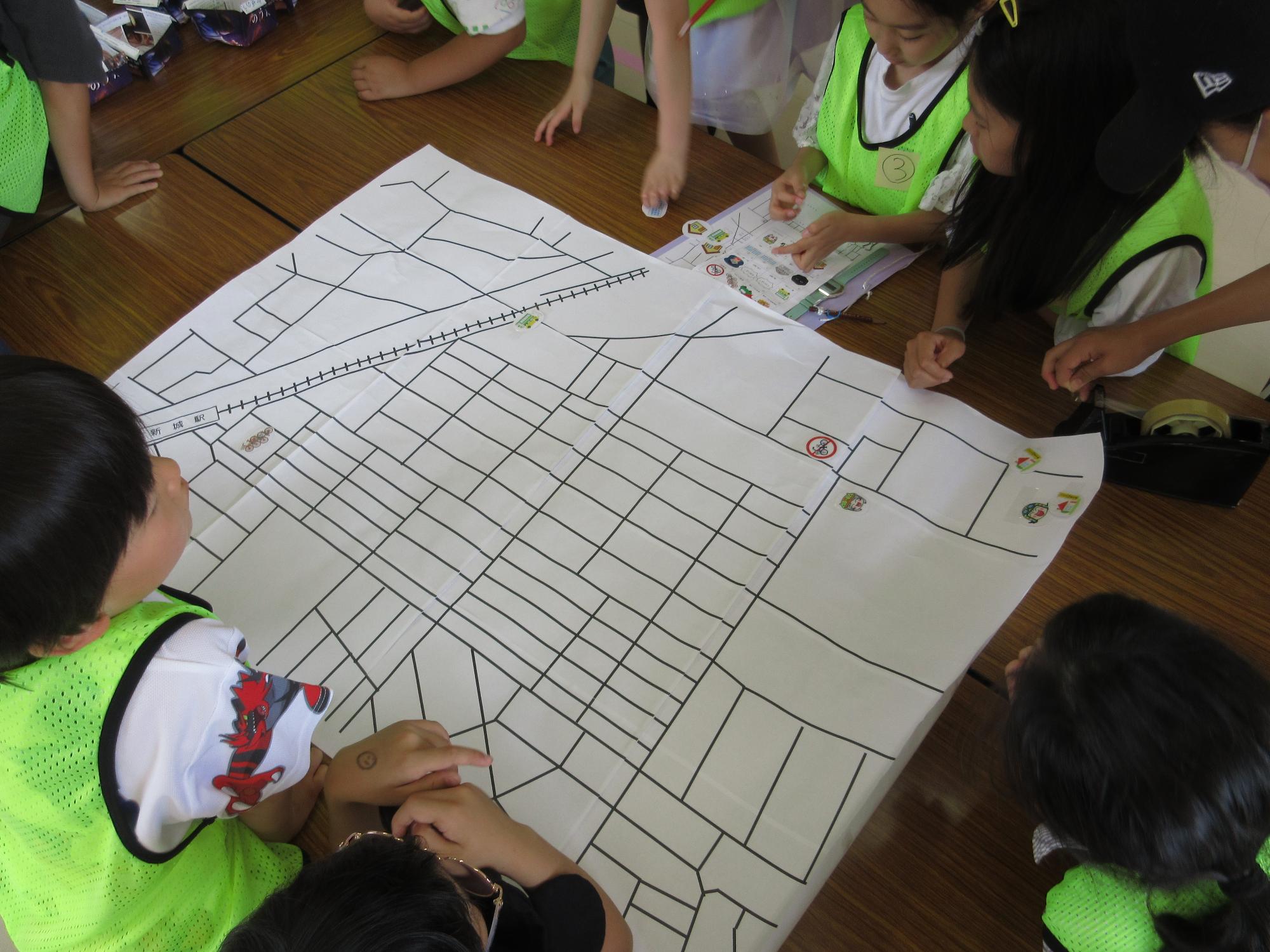 子どもたちが大きい地図にシールを貼っている写真