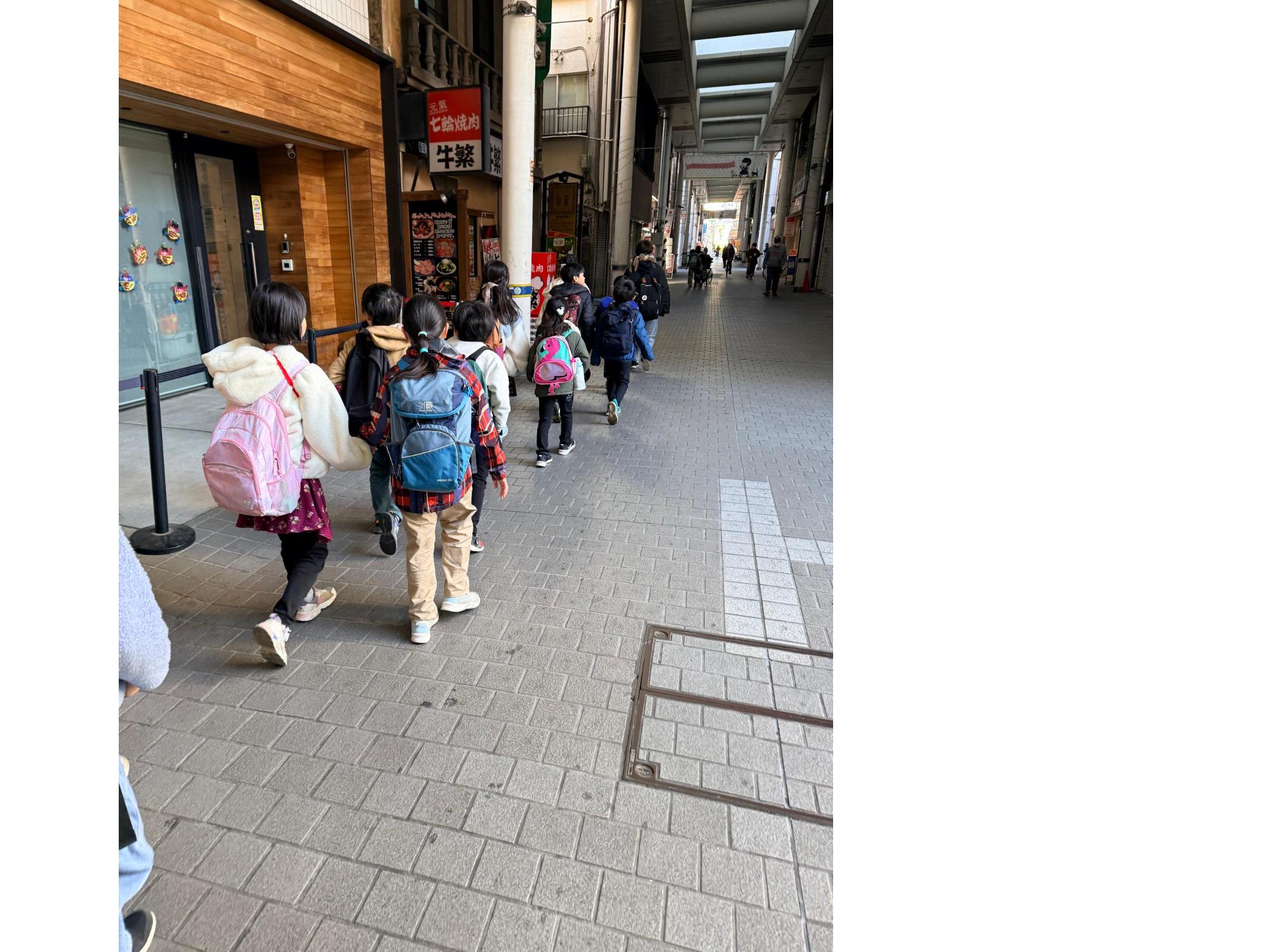 商店街を2列になって歩く子どもたち