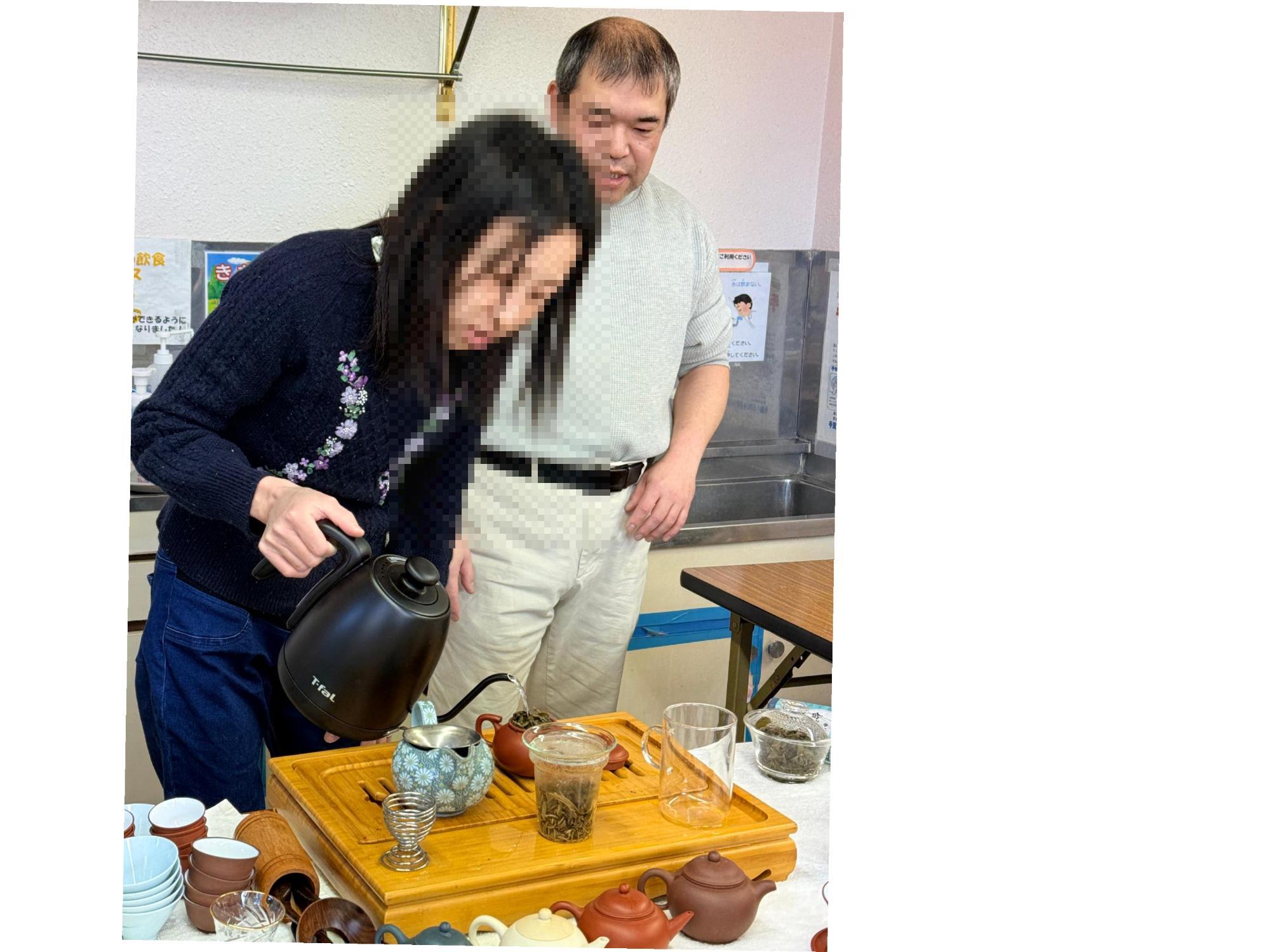 中国茶器のきゅうすにお湯を入れてお茶をいれる参加者