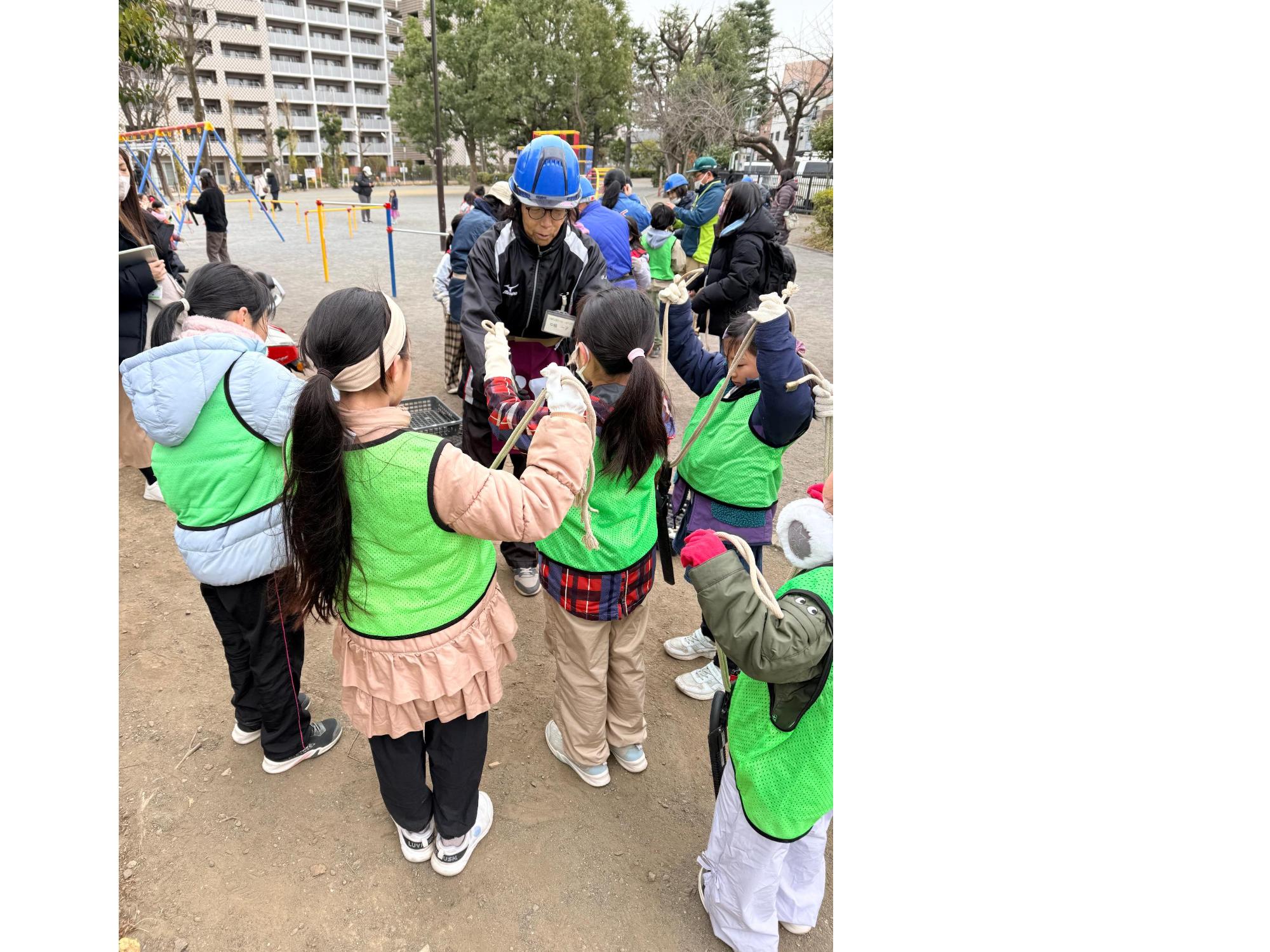 はさみとのこぎりのついたロープを腰に巻き選定の準備をする子どもたち