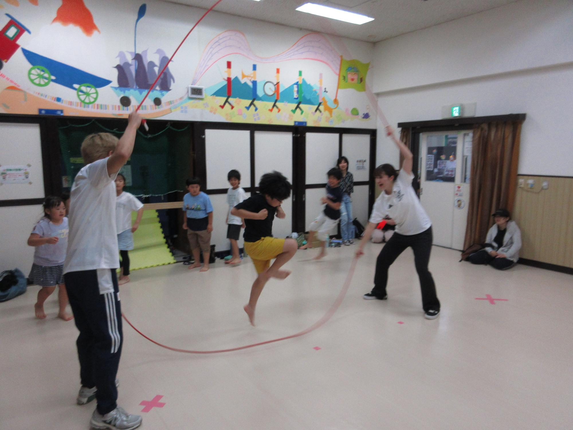 回っているロープの中に入ろうとしている小学生の写真