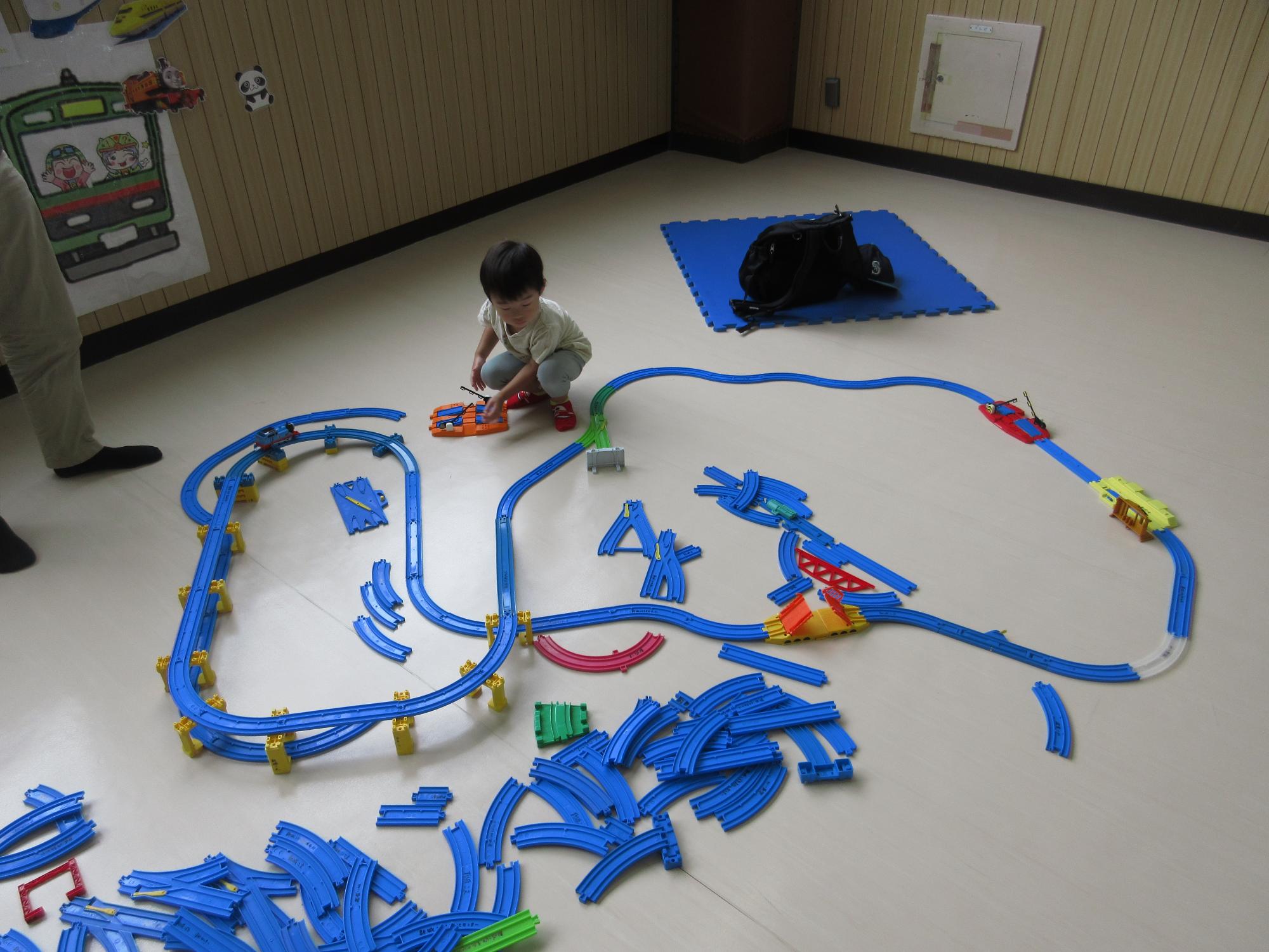たくさんのプラレールをつなげている様子の写真