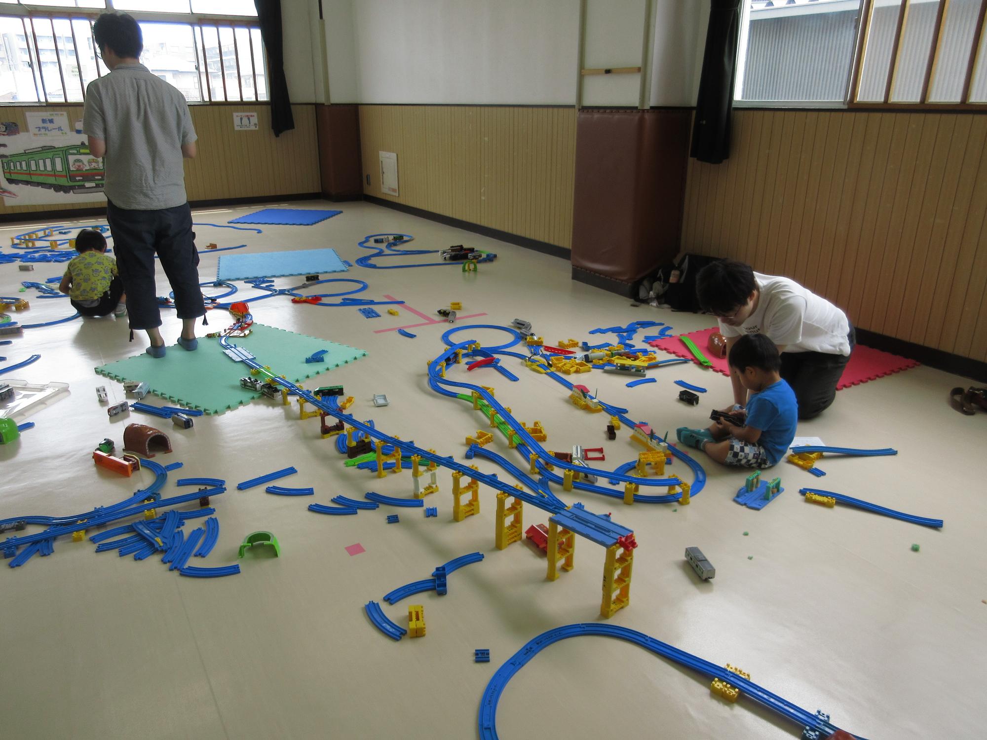 長いプラレールの線路を作っている様子の写真