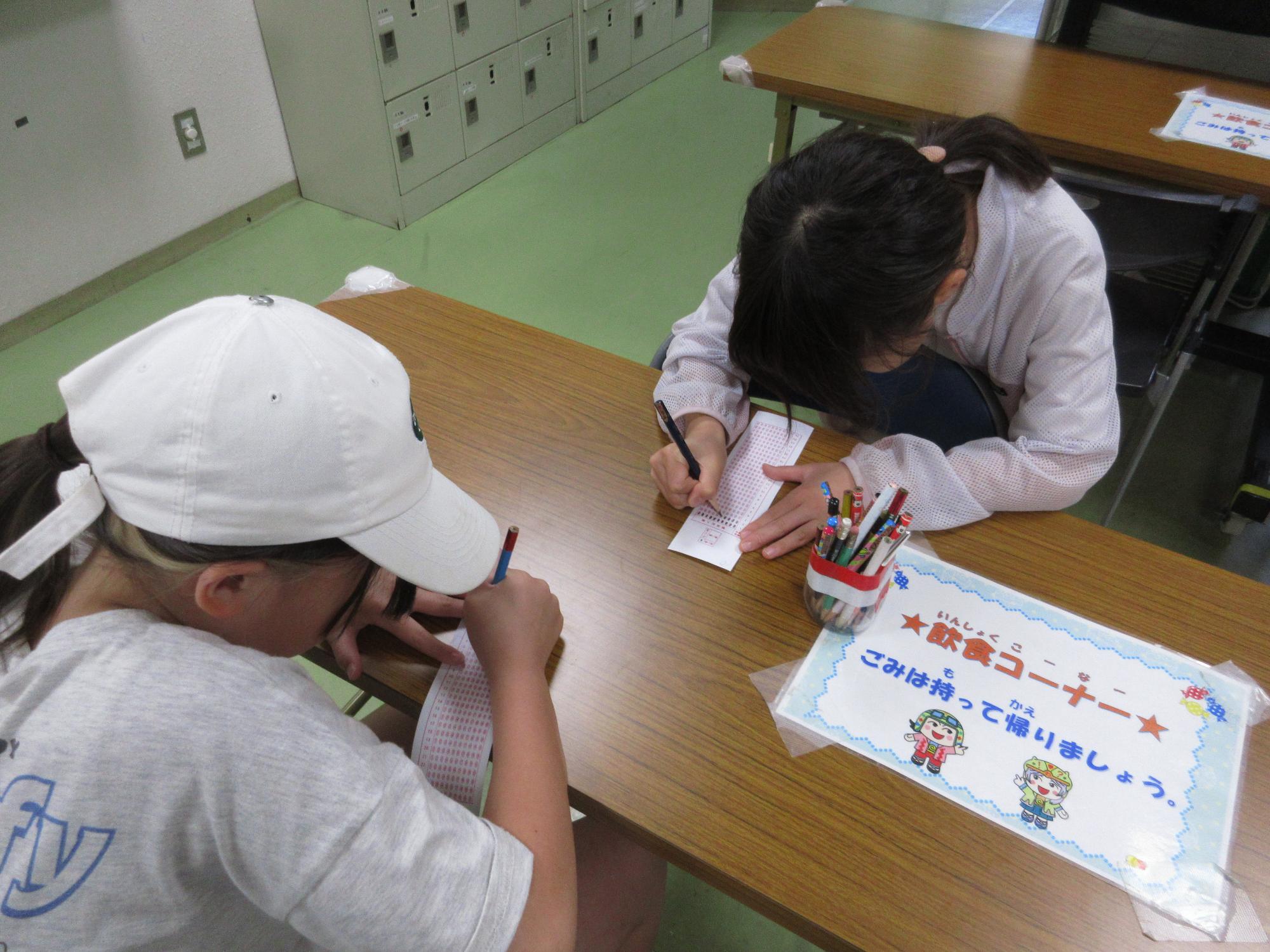 マークシートを塗りつぶす小学生2名の写真