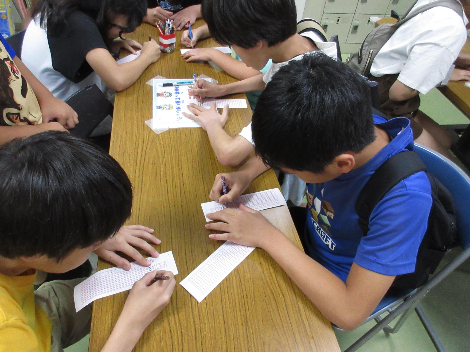 マークシートを塗りつぶす小学生4名の写真