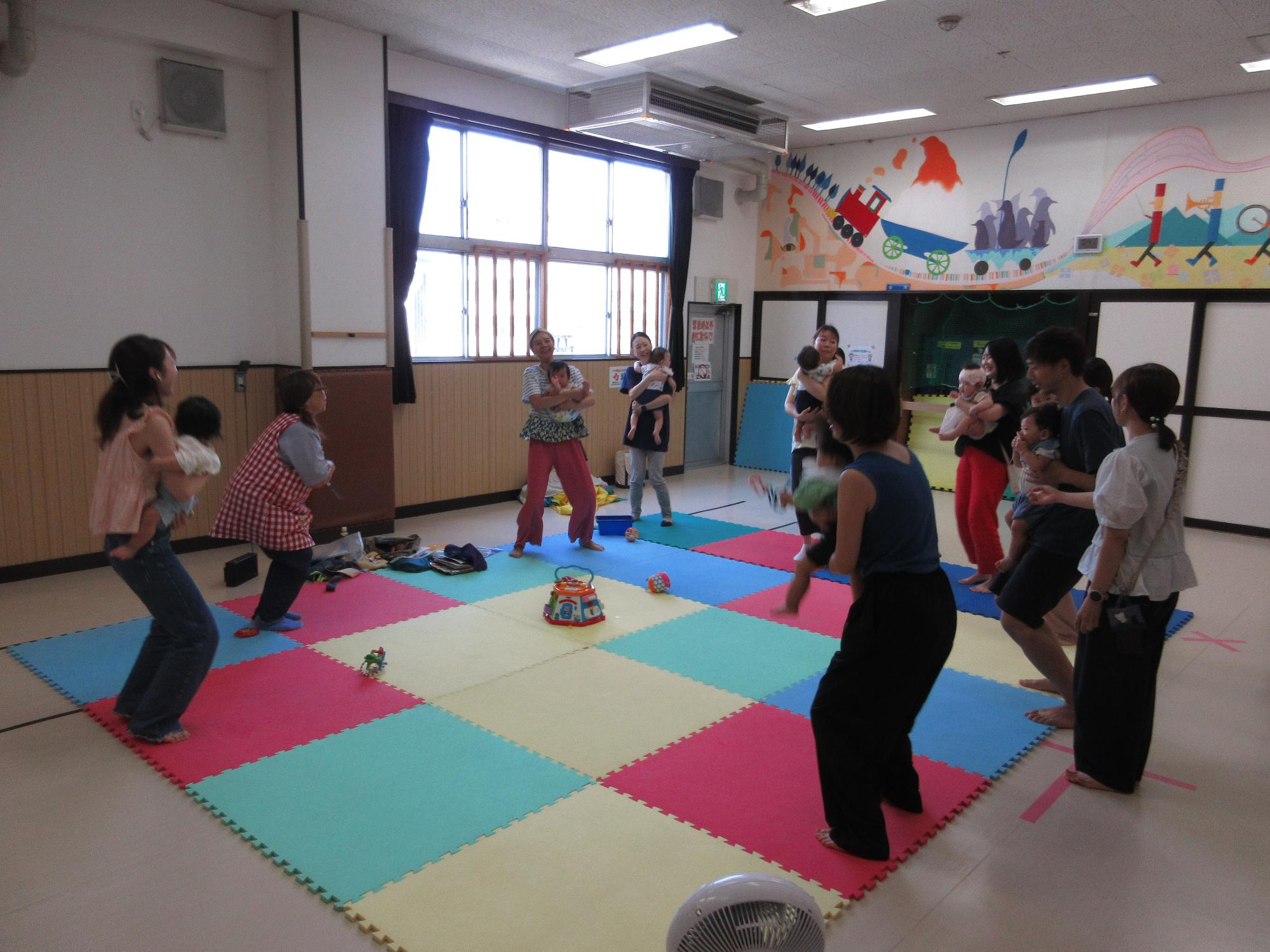 赤ちゃんがパパとママに抱かれて体操してます