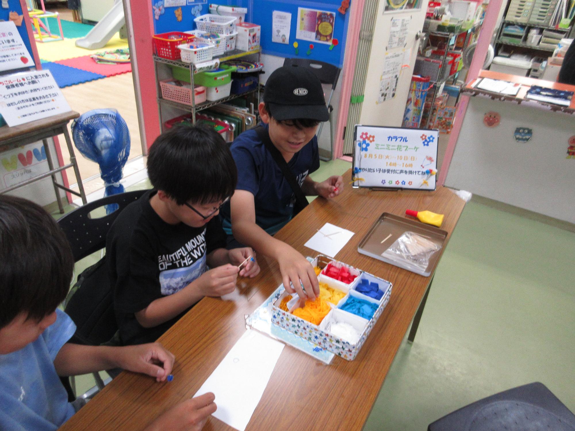 好きな色の花紙をワイヤーにボンドを付けた刺しているところ