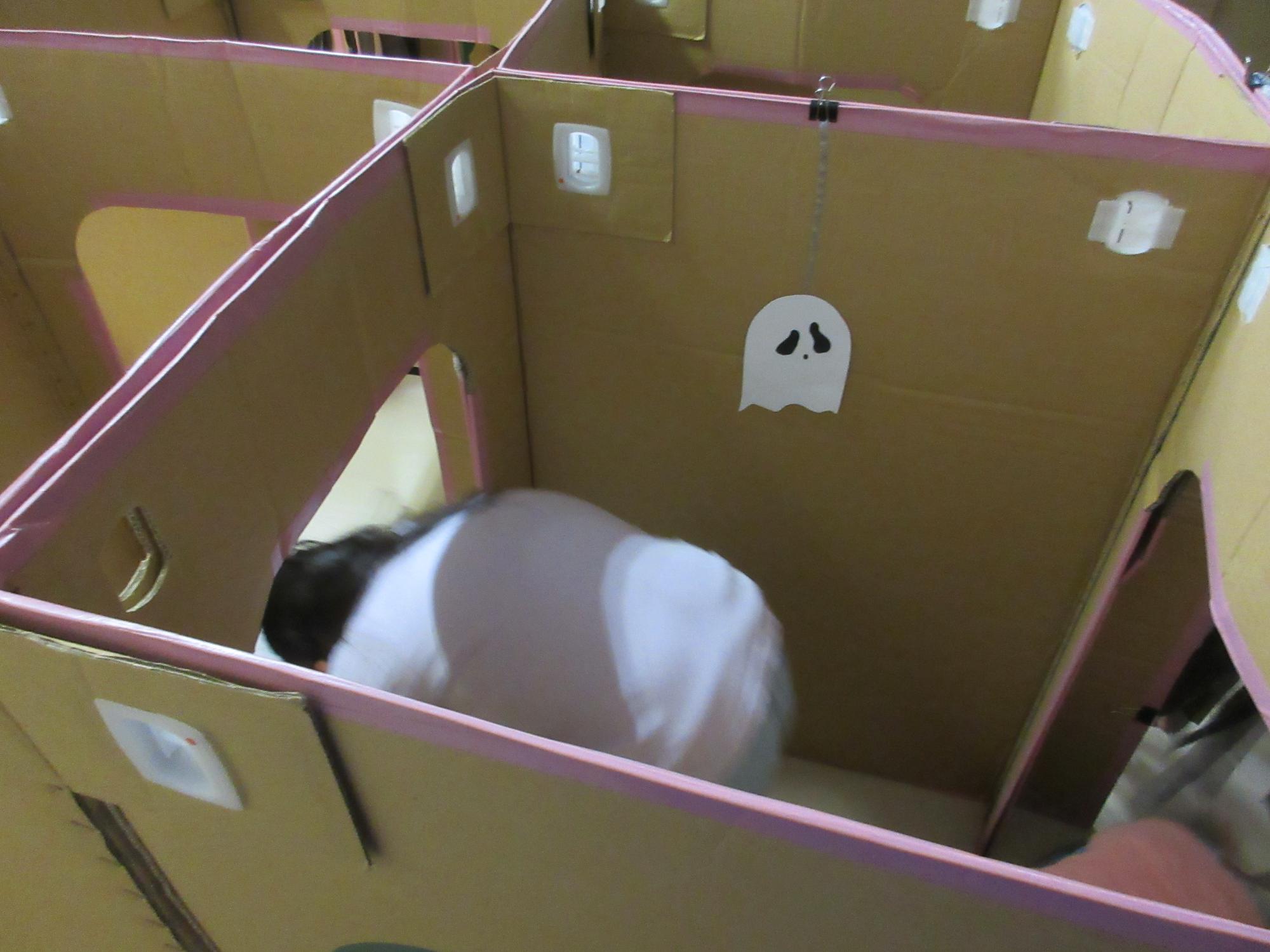 身体をかがめて迷路を進むこども