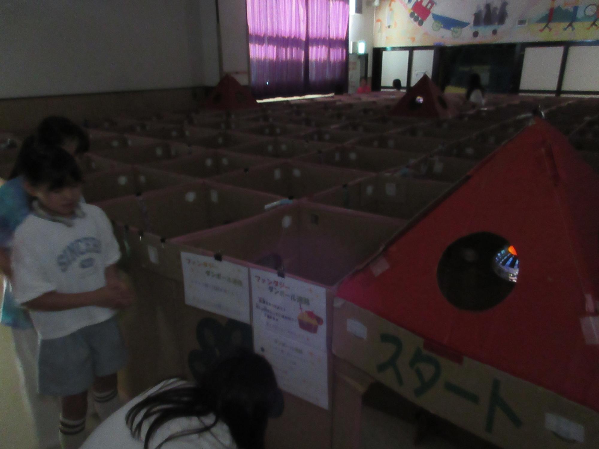 暗い部屋でランタンの明かりで迷路を楽しむ様子