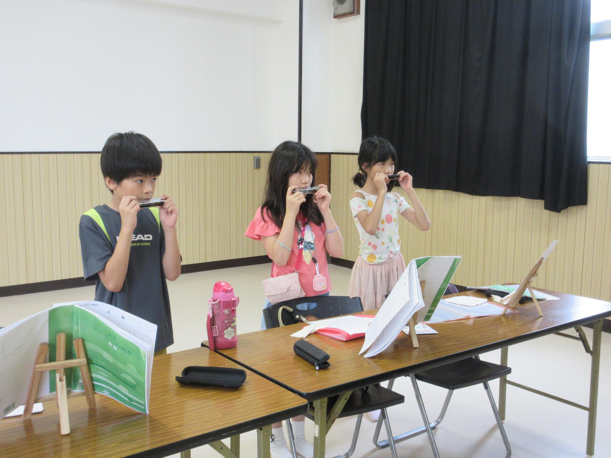ハーモニカを立って吹く子どもたち