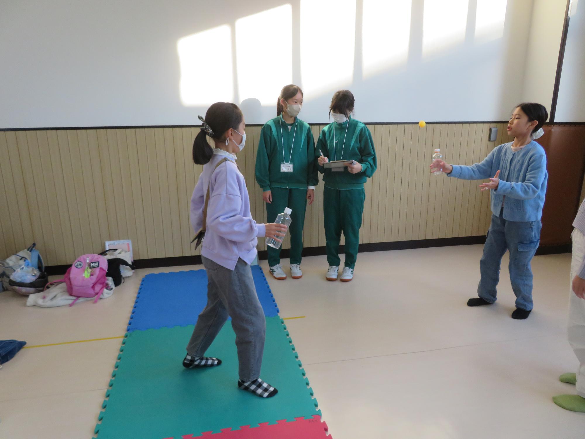 ペットボトルでピンポンを弾ませるこども