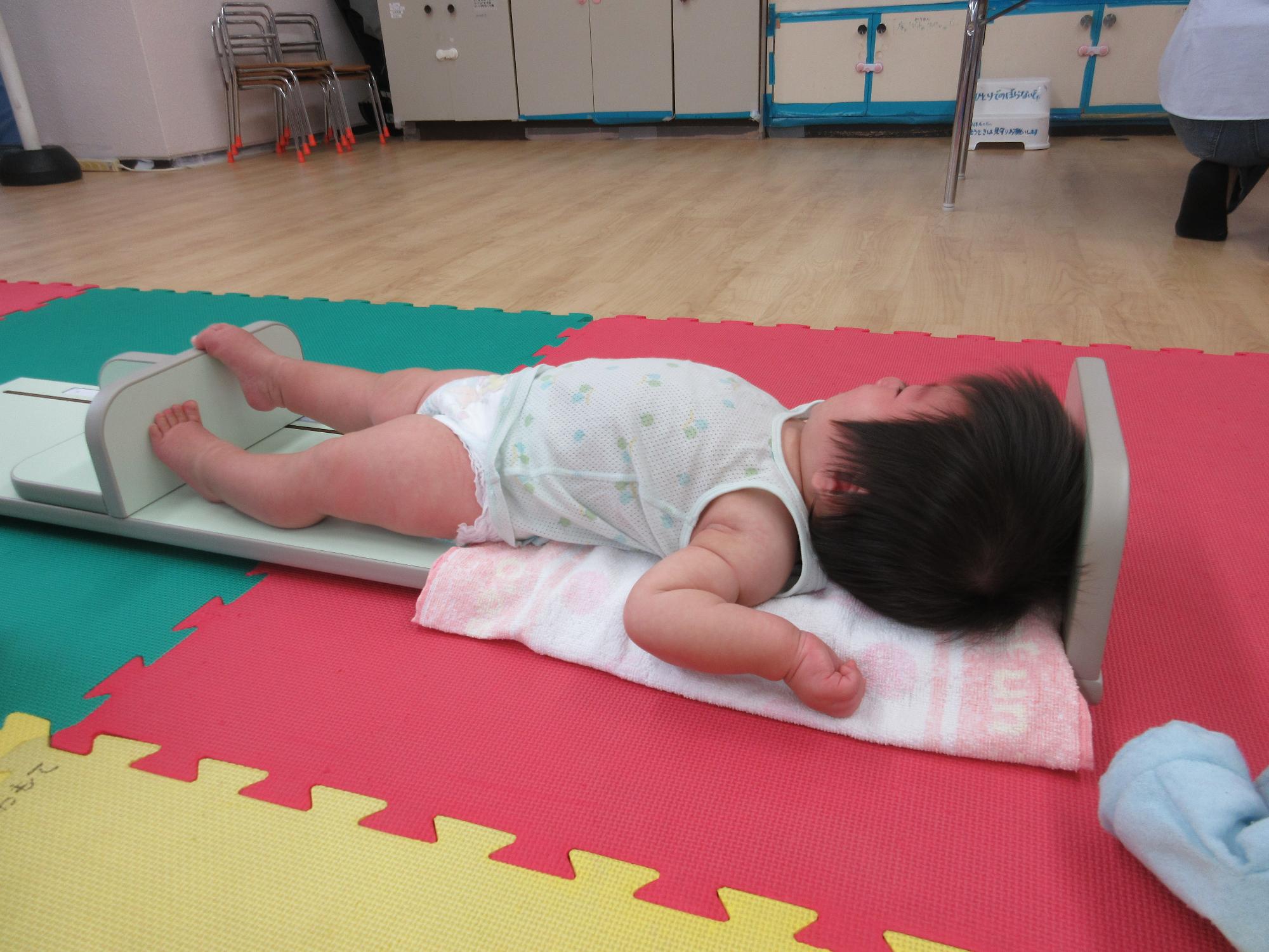 身長を計測する乳児