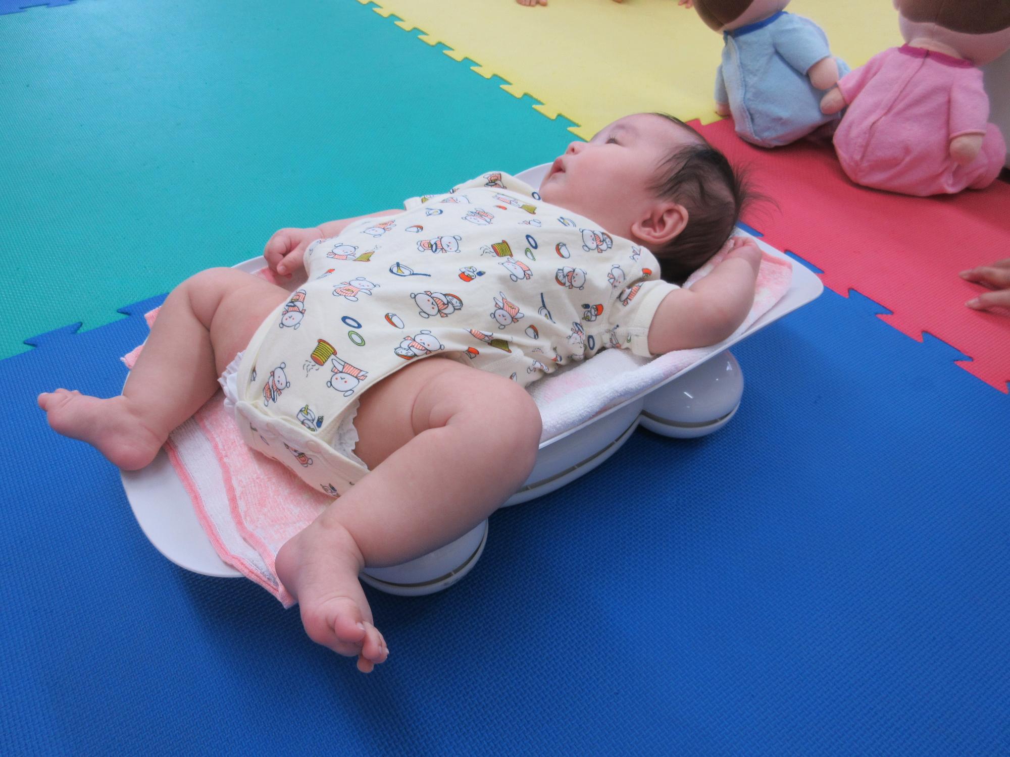 体重を測定する乳児
