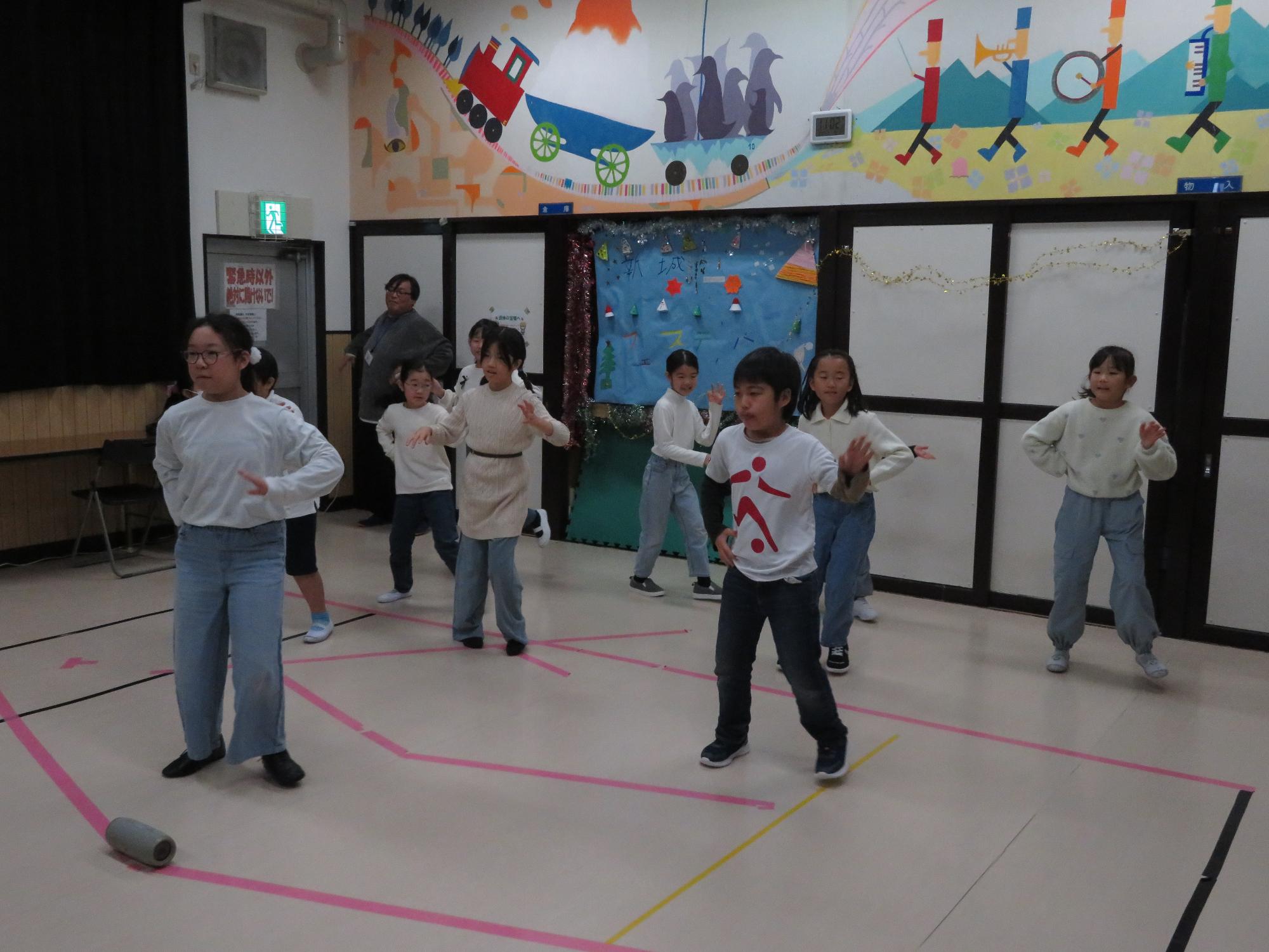 上は白、下は青のお揃いの衣装でダンスをするメンバー