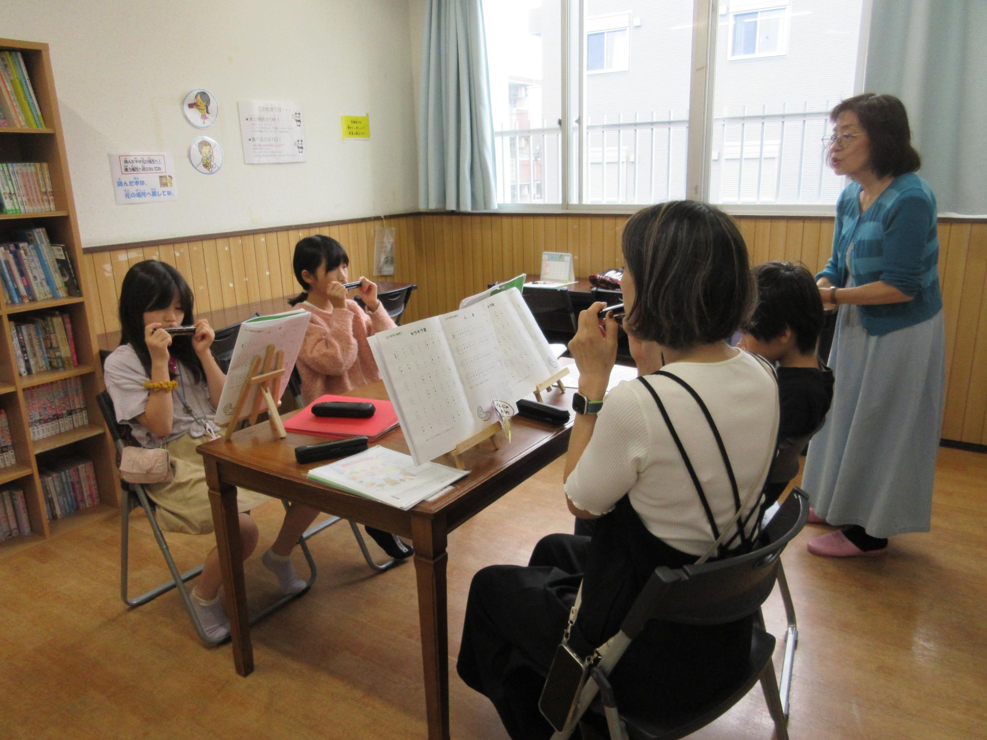 楽譜を見ながらハーモニカを吹いています