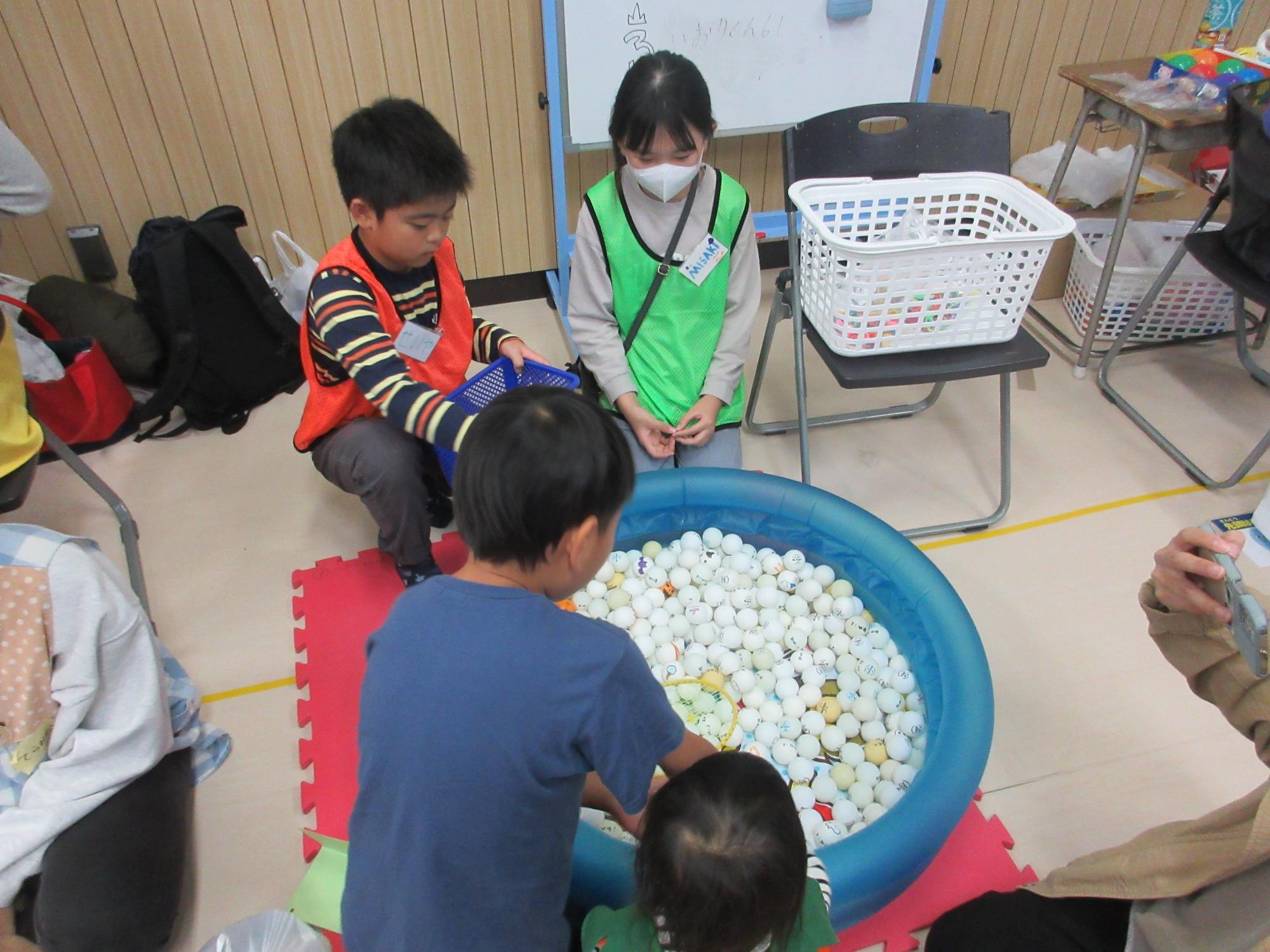 ピンポン玉すくいをする子どもたち