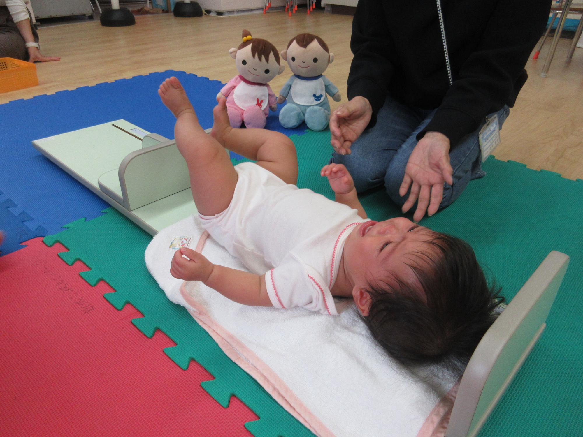 身長を測る乳児