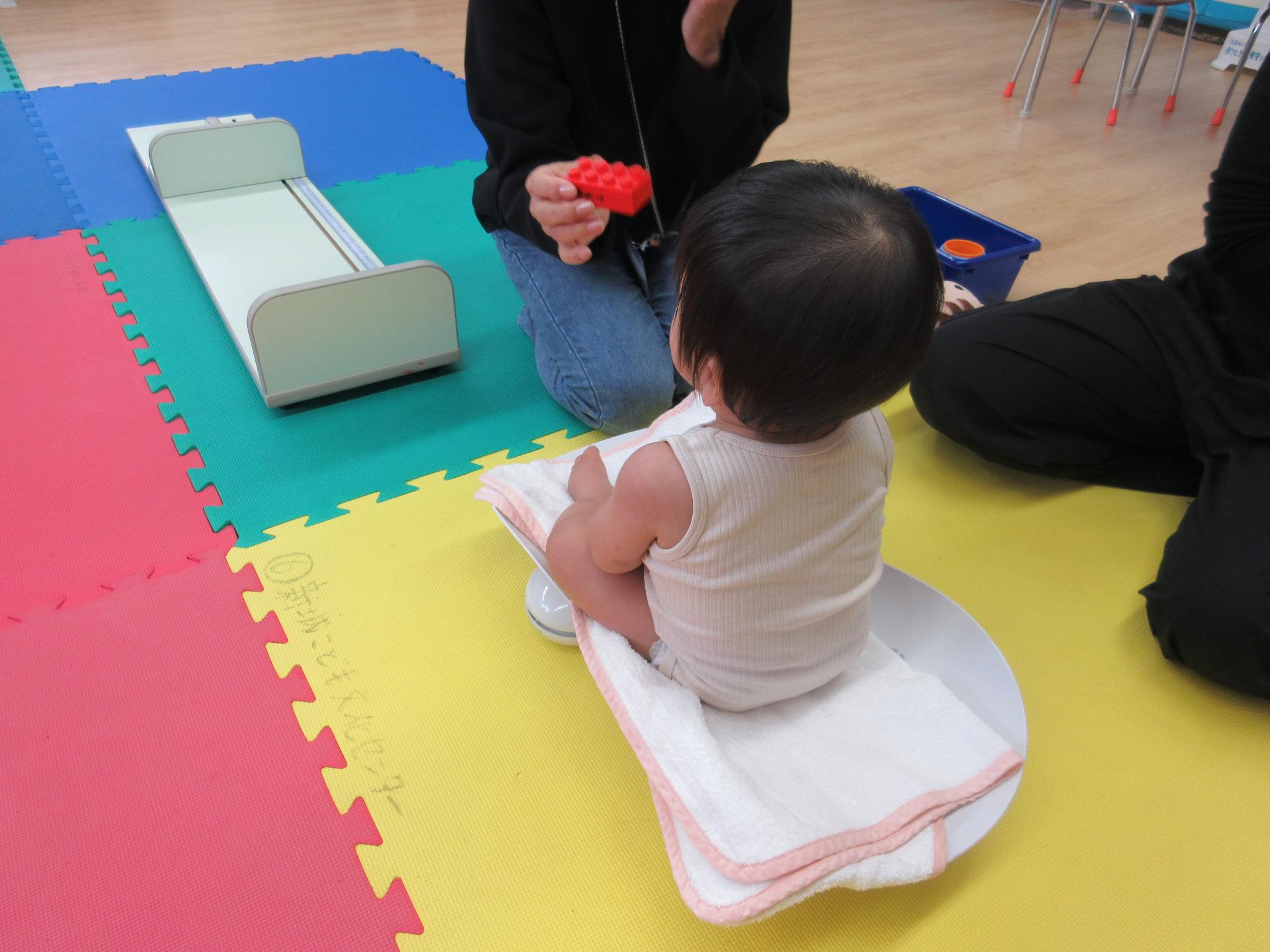 体重計にのる乳児