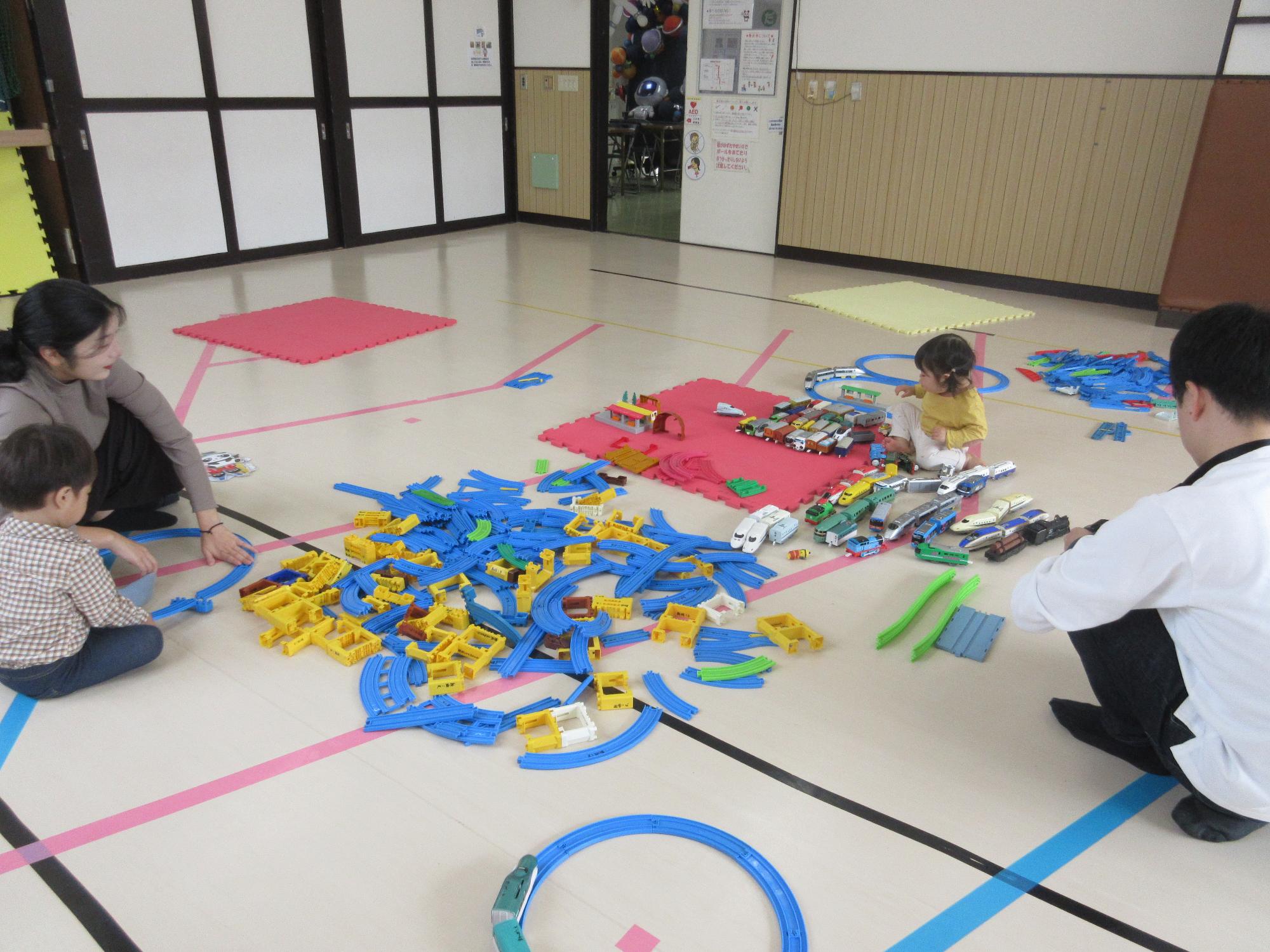 たくさんの線路で何を作ろうか考える乳幼児親子