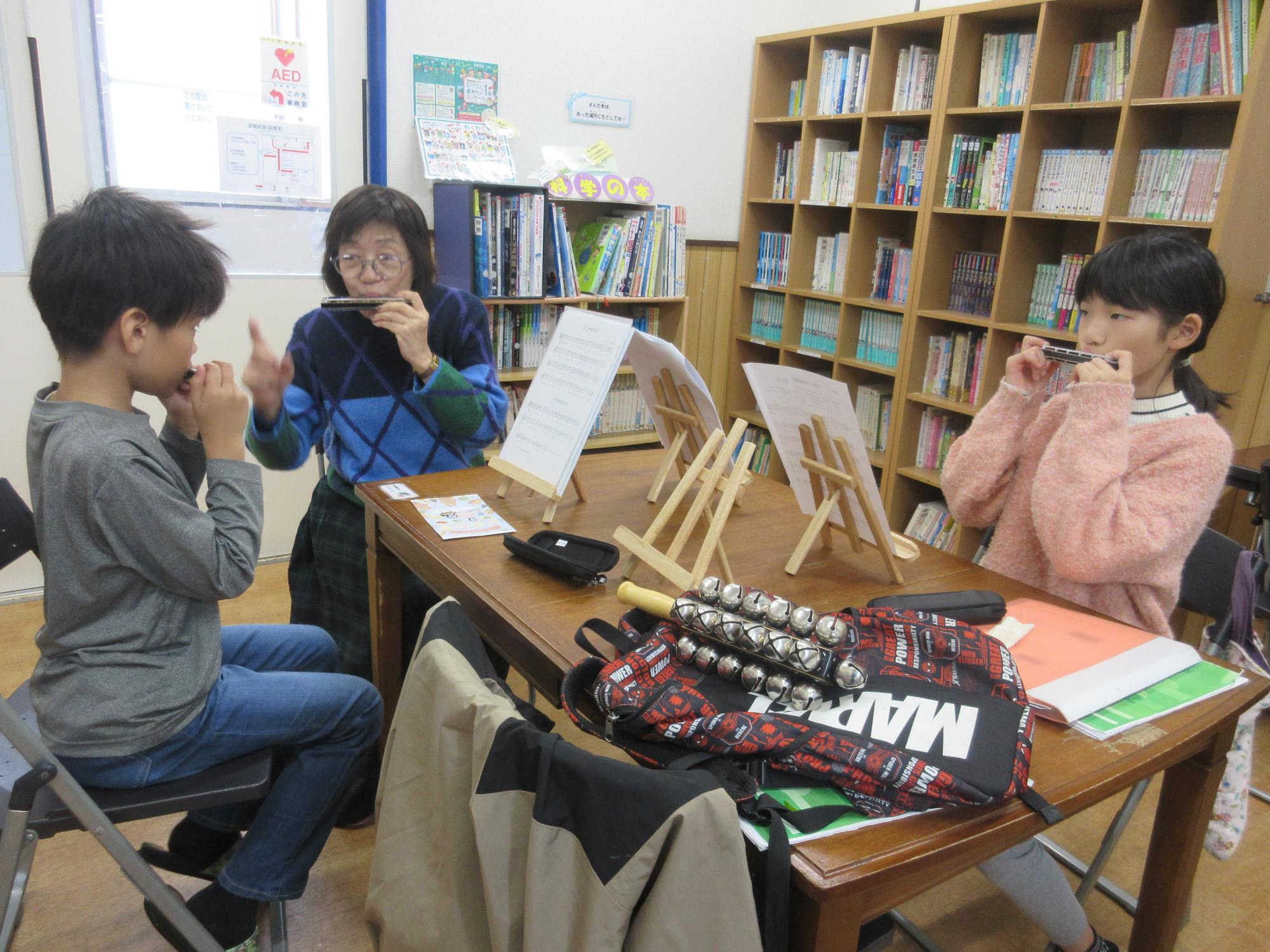 指導を受けハーモニカを吹く子どもたち