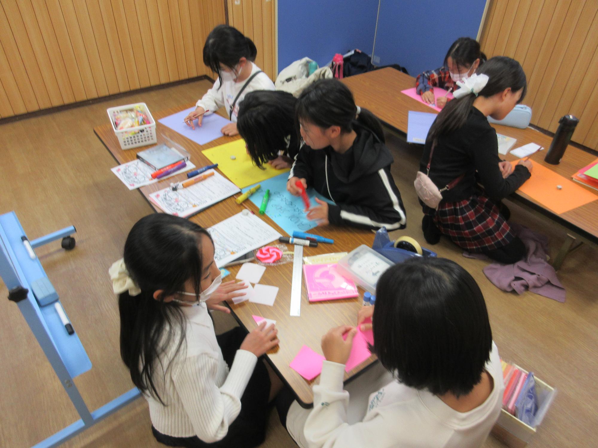 キャンディーショップのカラフルなポスターを作る子どもたち