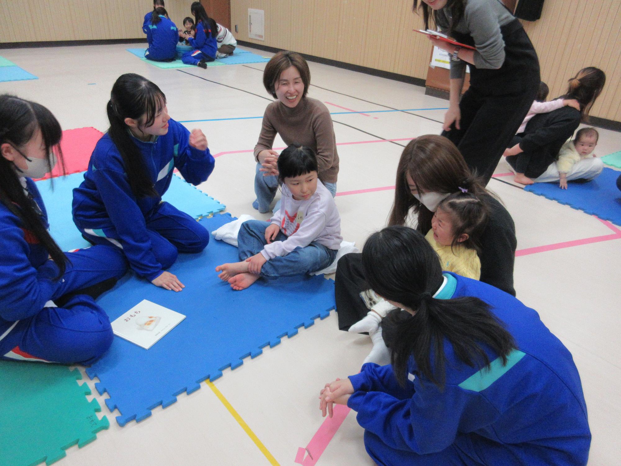 高校生に読み聞かせをしてもらっている子ども達