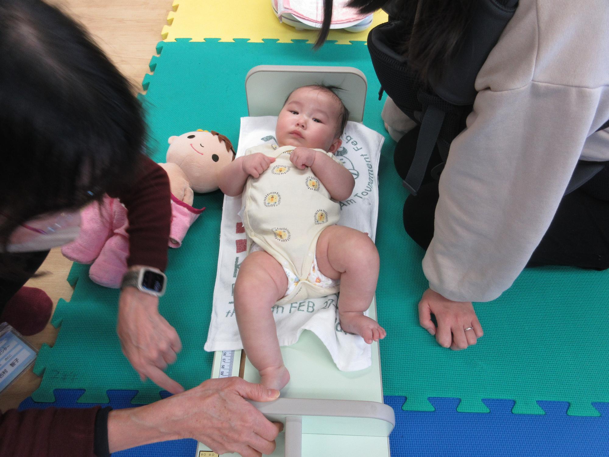 乳児が身長を測っている様子