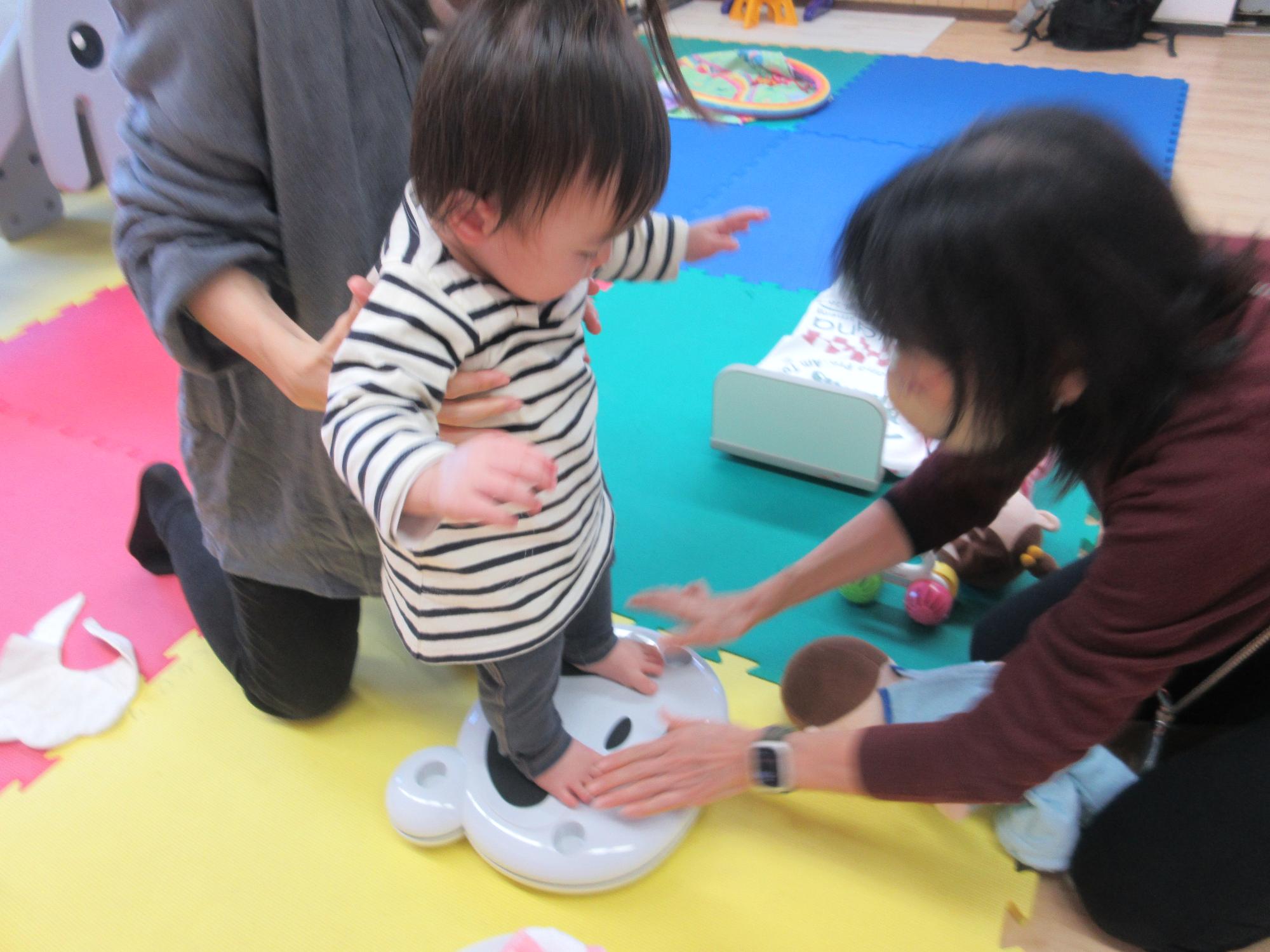 幼児が体重計に乗っている様子