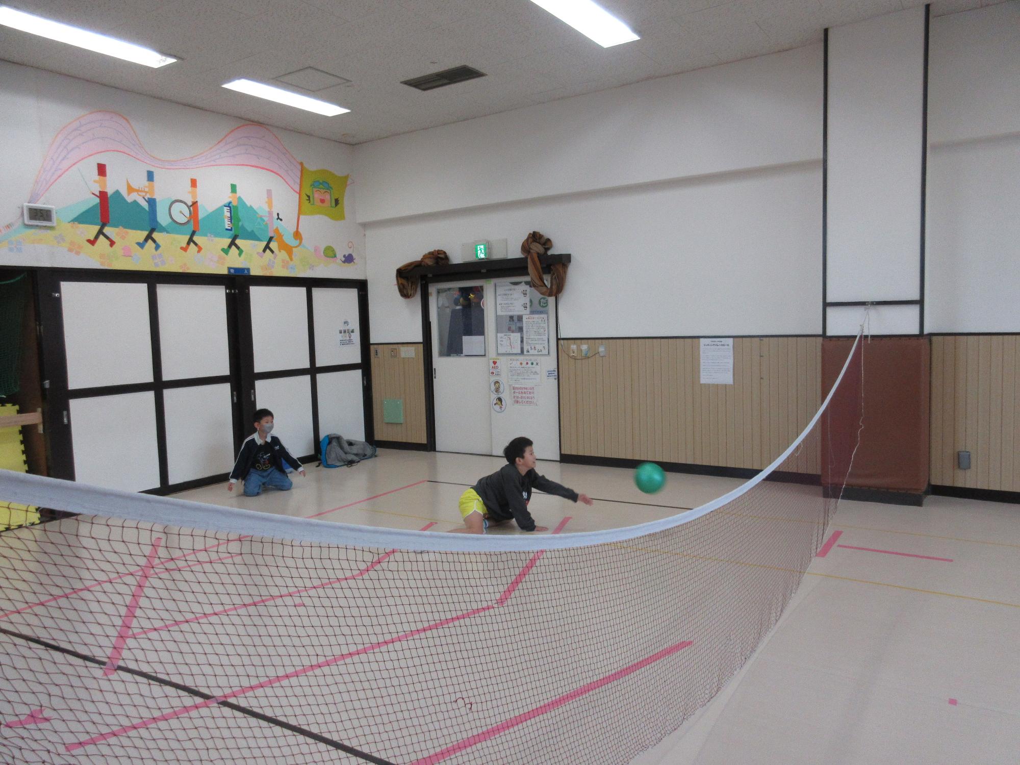 シッティングバレーでレシーブをする子ども