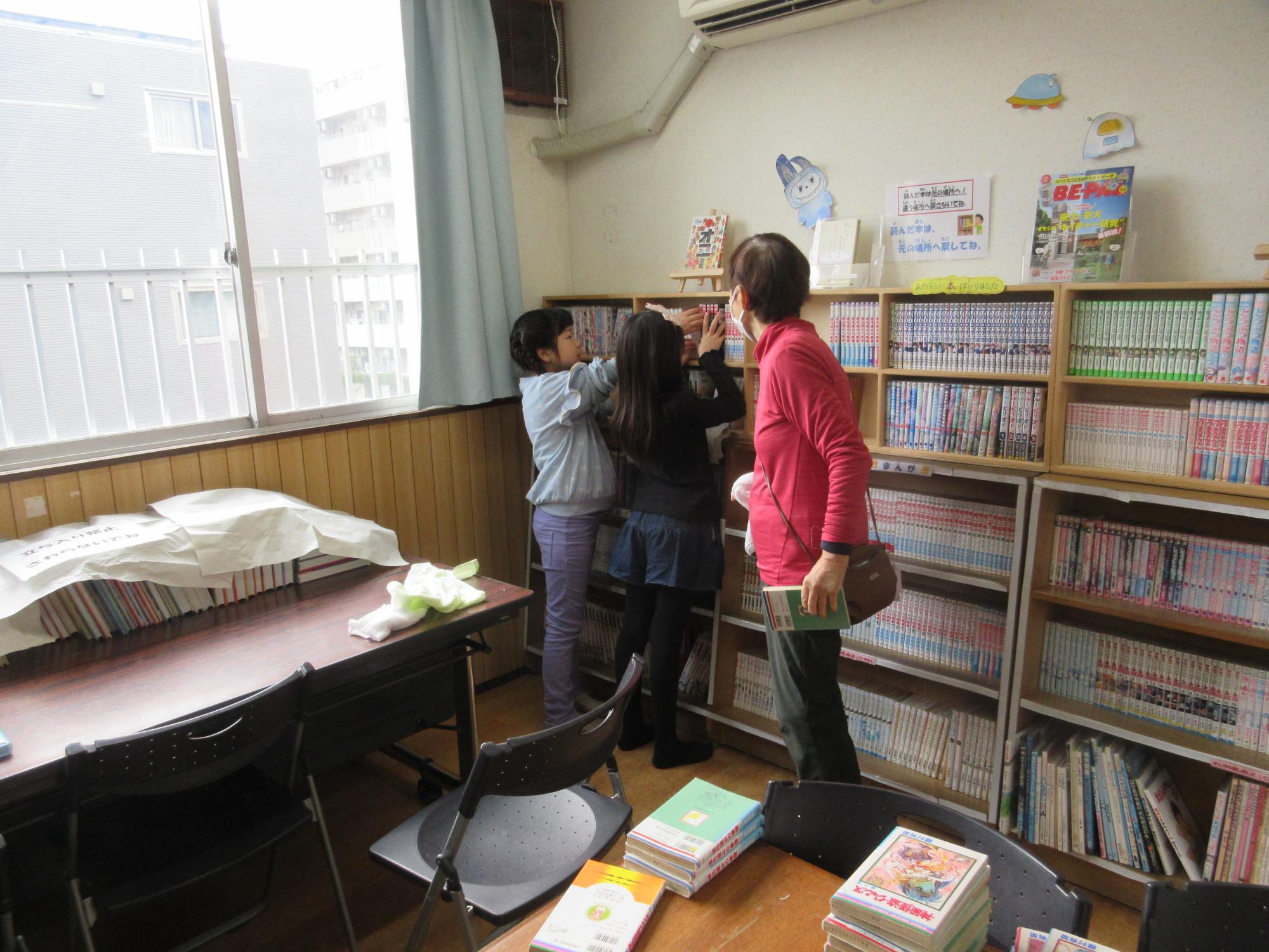 本棚を掃除するこども