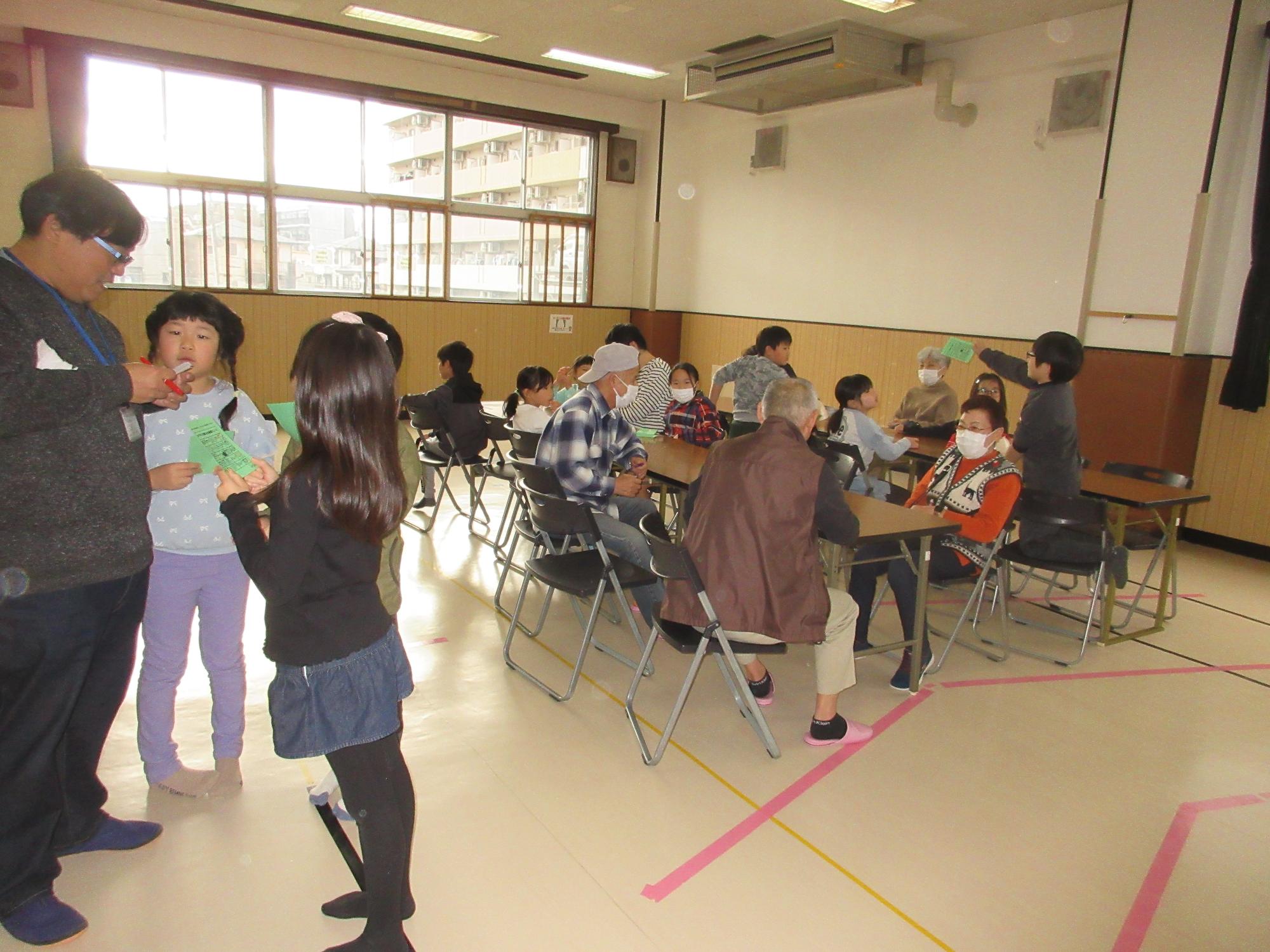 ビンゴカードに印をつけてもらう子どもたち