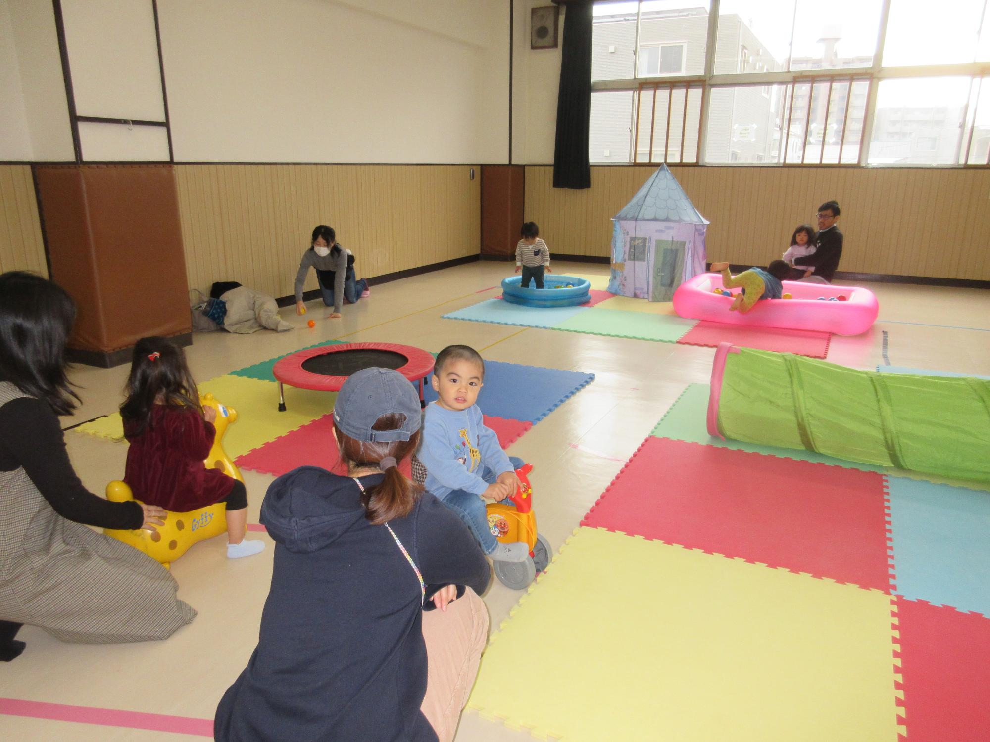 広いお部屋で子どもたちが遊んでいる写真。