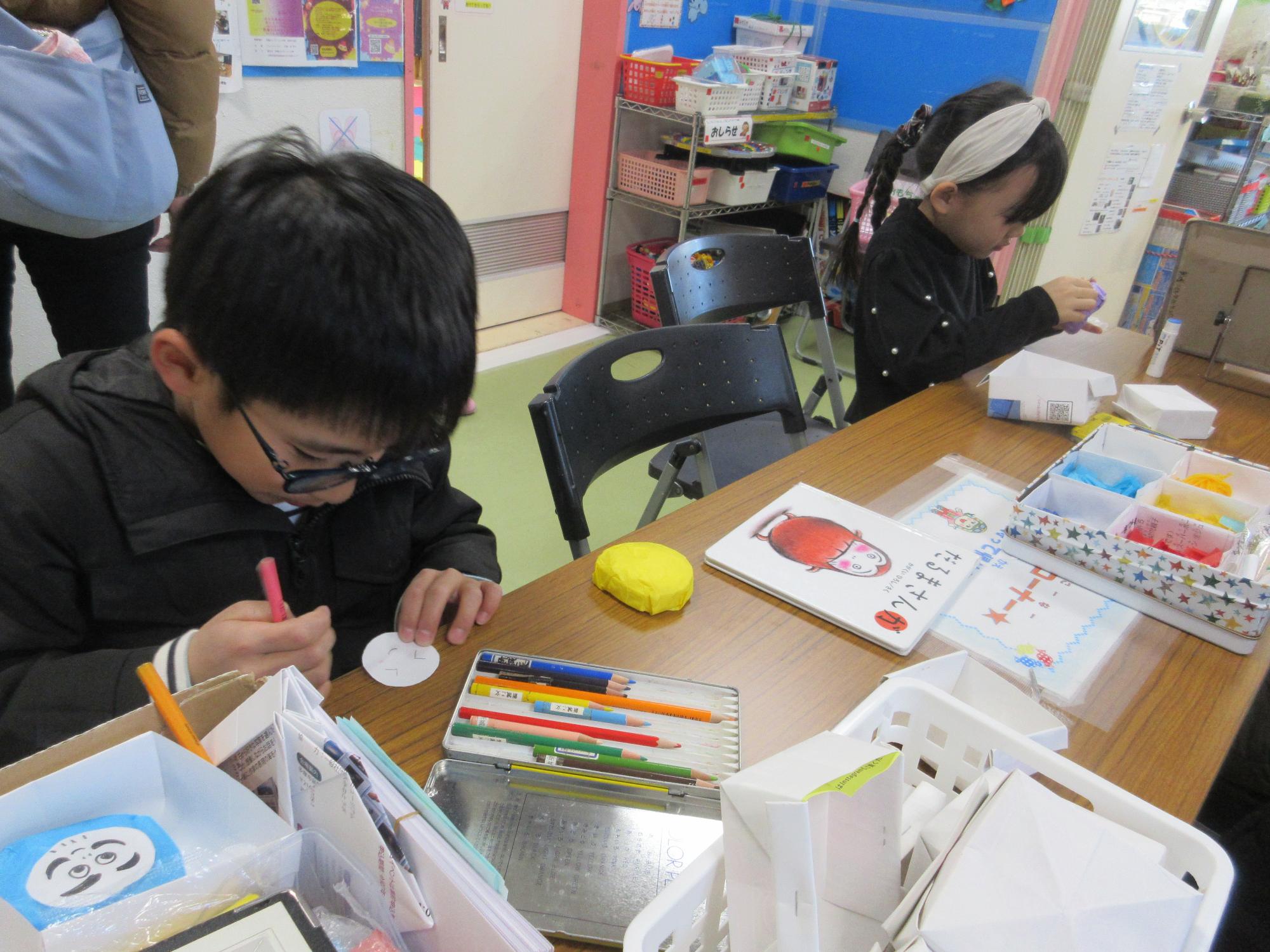 だるまさんがのイラストを参考に絵を描く子どもたち