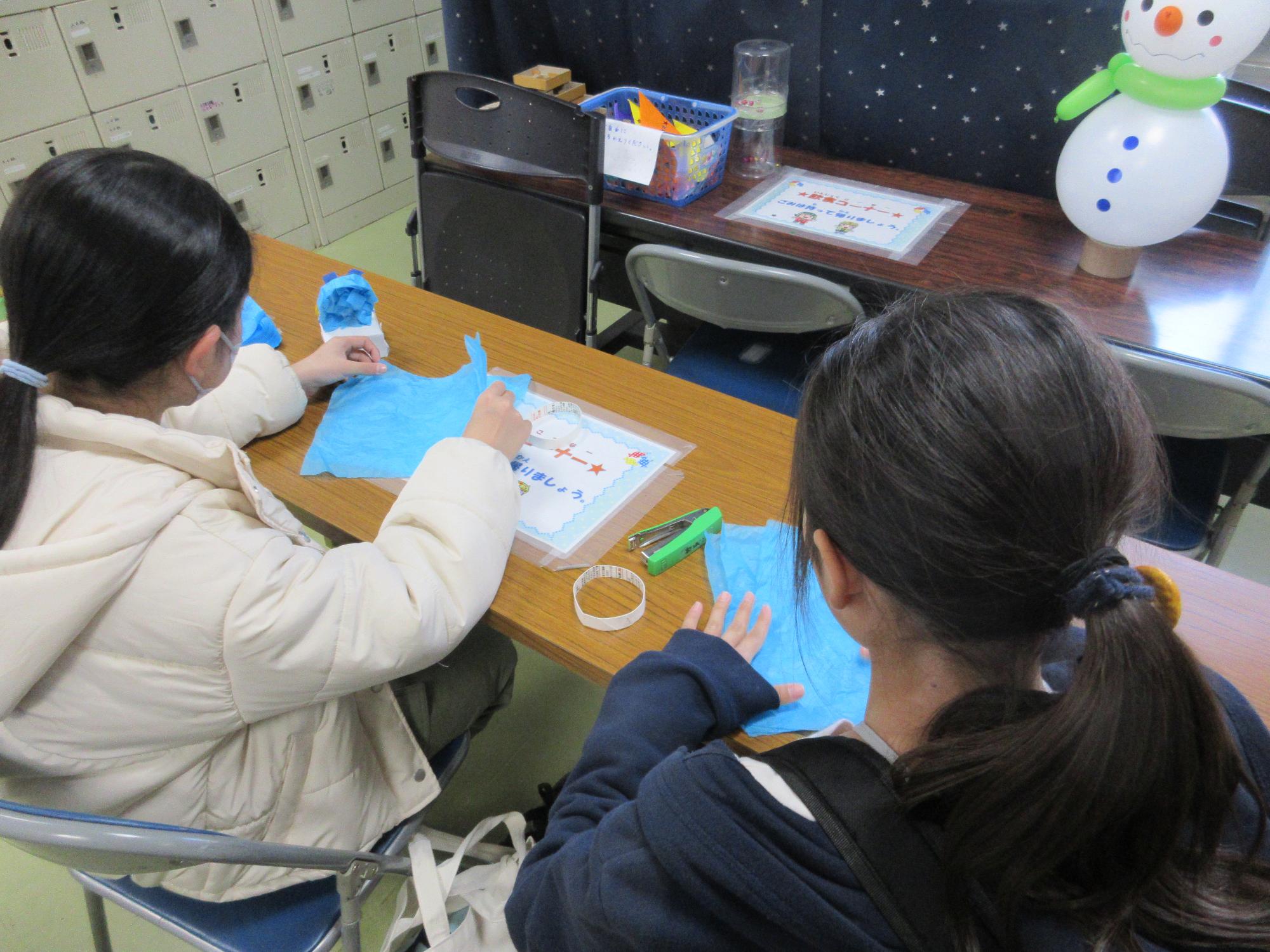 おはながみでだるまを作る子どもたち