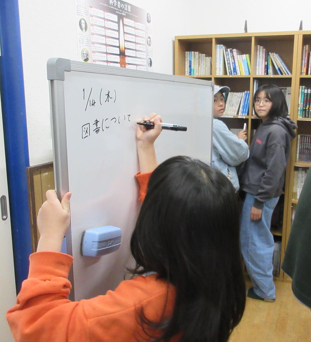 議題をホワイトボードに書く子ども