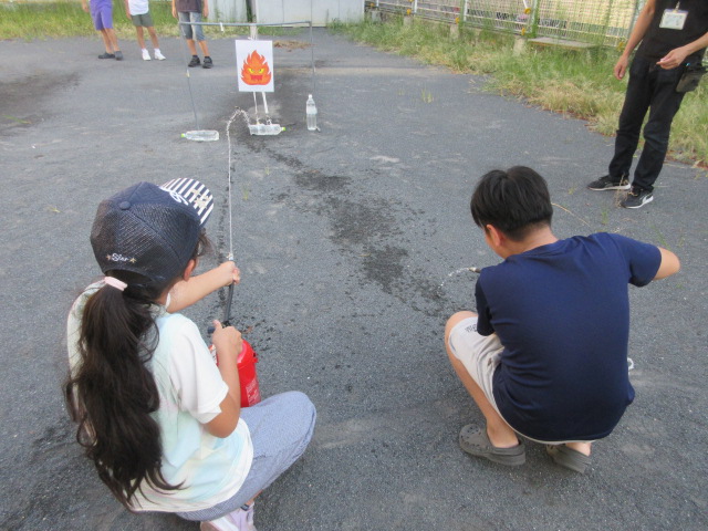 火元をねらって水消火器を向ける子どもたちの様子の写真