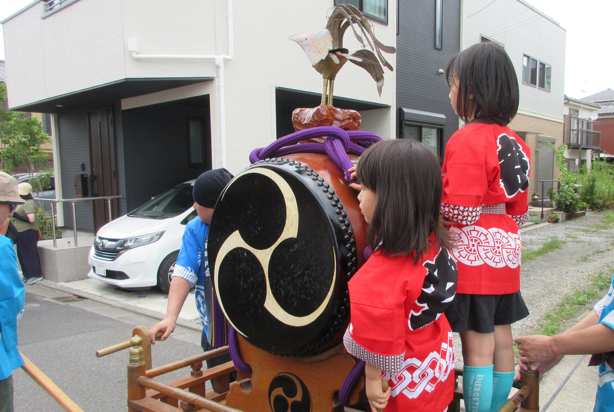 撥を左手に山車に乗る子どものようすの写真