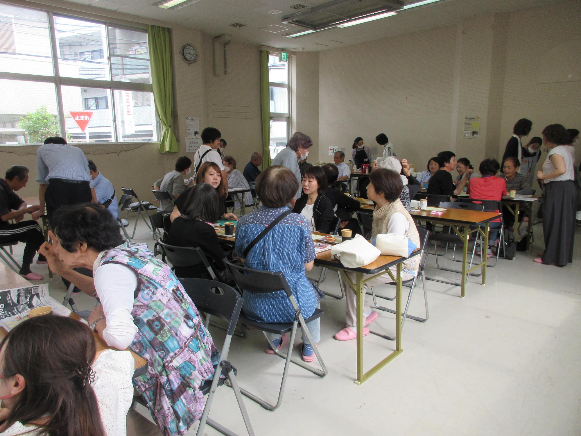 コーヒーやお茶、お菓子を囲みながら談笑している地域の人の様子の写真