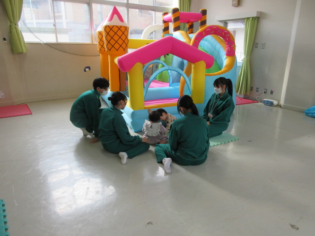 エアー遊具で幼児さんに優しく対応をする中学生の様子の写真