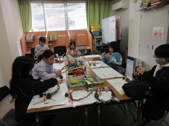 庭で育てたさつまいものツルを利用してクリスマスリースを作る子どもたちの様子の写真