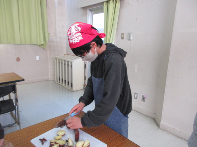 高学年のお兄さんがお芋を上手に切っている様子の写真