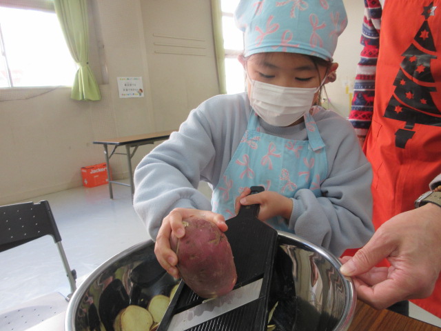 お芋をスライスしている子どもの様子の写真