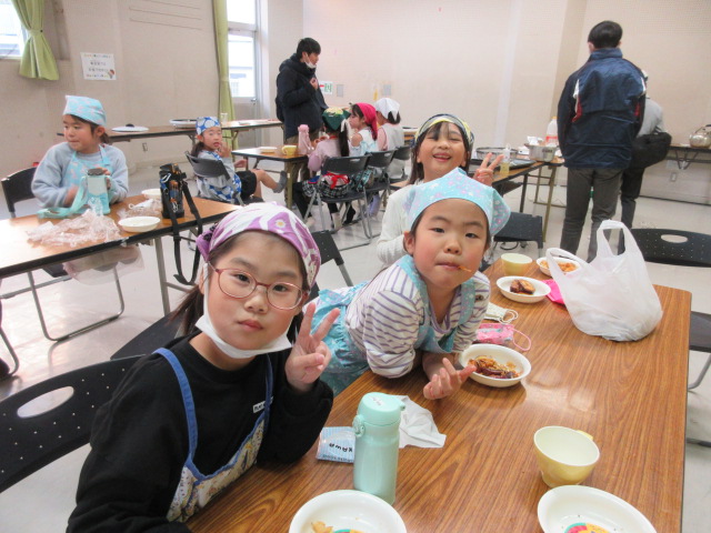 大学芋とさつまいもチップスを頬張る子どもたちの様子の写真