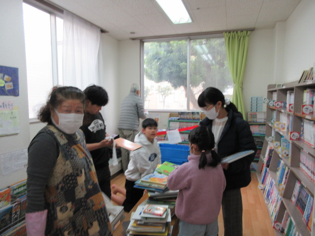 図書室で本を拭き、整理整頓する様子