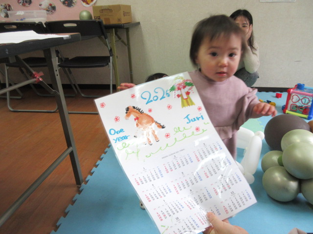 完成したカレンダーに興味津々の様子の幼児の写真