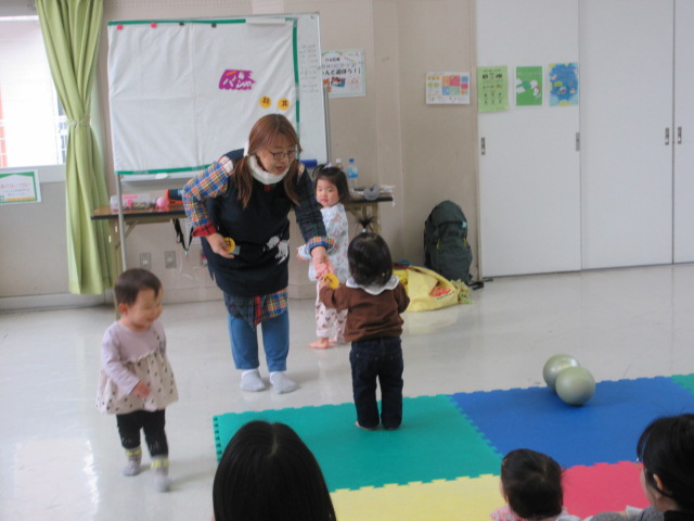 メロンパンの歌を歌いながらメロンパンのおもちゃと受け取る幼児の様子の写真