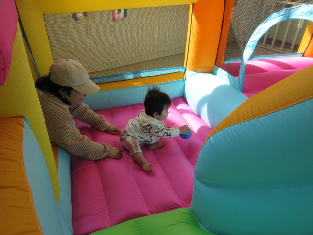 バルーン遊具に挑戦している乳幼児親子の様子の写真